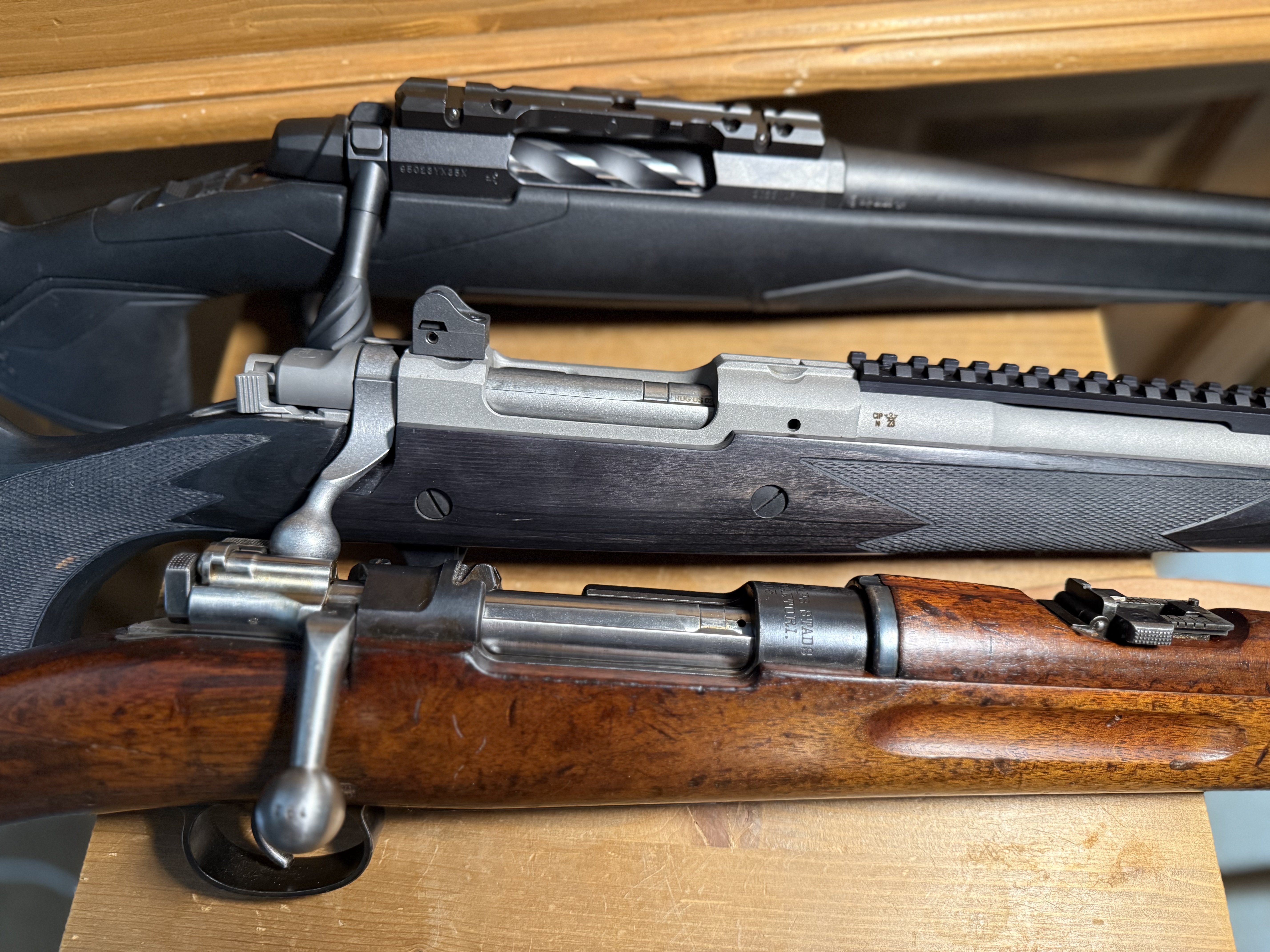un Mauser su�dois mod. 94 � alimentation contr�l�e (en bas), une Ruger 77 Scout dont l'action s'inspire du Mauser 98 (au milieu), une Browning X-Bolt II � syst�me push-feed (en bas).