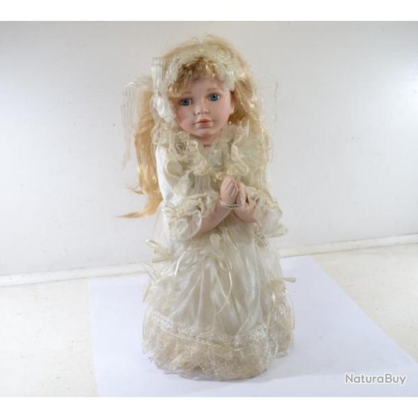 Poup�e en porcelaine � genoux, pri�re prie. Robe en dentelle blanche