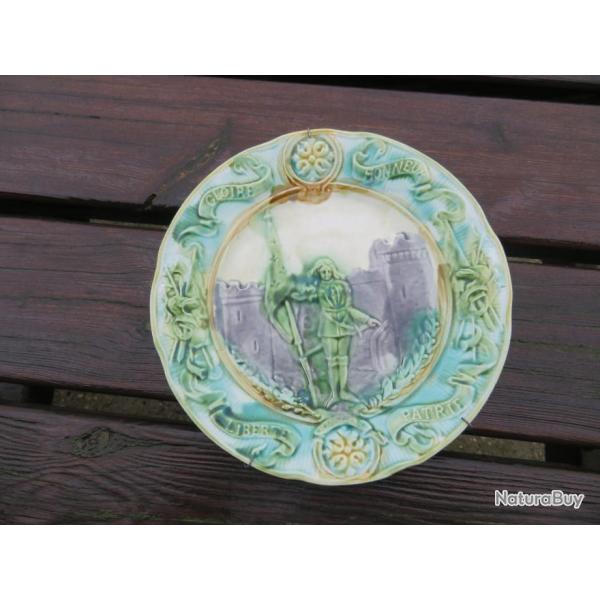 Assiette en barbotine, de la faencerie d'Onnaing, reprsentant "Jeanne d'Arc"en armes avec tendard