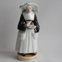Tisanière porcelaine figurative Nonne tenant une tasse de thé