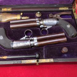 Coffret d'une paire de poivri&egrave;res sign&eacute;es calibre 12 env &agrave; balles forc&eacute;es.