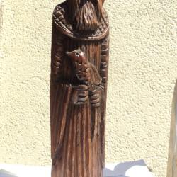 Sculpture massive en bois repr&eacute;sentant un homme avec un oiseau