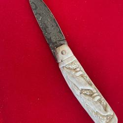 Couteau artisanal manche cerf avec sculptures aux c&eacute;tac&eacute;s lame damas sign&eacute;e