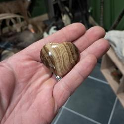 Pierre polie et sculpt&eacute;e en forme de coeur ; bois fossilis&eacute;
