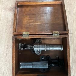 Magnifique ensemble de deux canons d'alarme, pr&eacute;sent&eacute; dans un &eacute;l&eacute;gant coffret en bois.