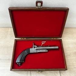 Superbe pistolet &agrave; broche calibre 9 pr&eacute;sent&eacute; dans son coffret de rangement.